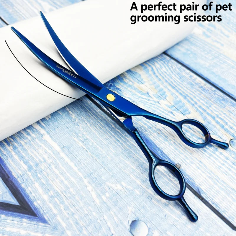 Blue pet grooming scissors on folded white towel with curved blades