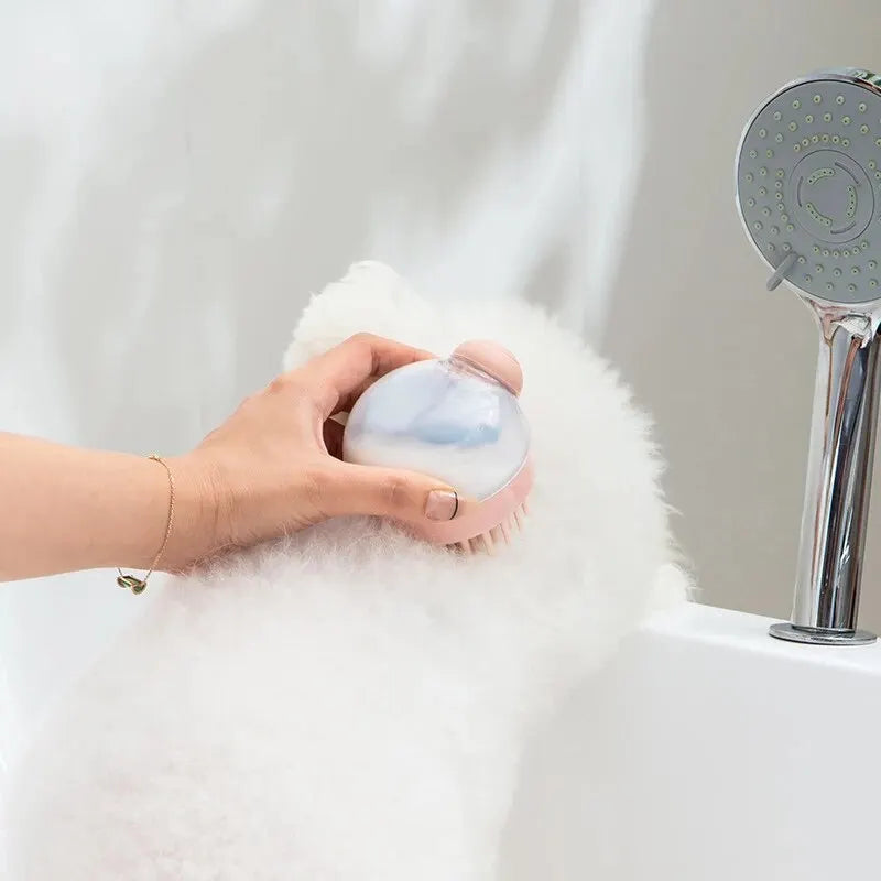 Pink silicone pet brush head held in hand, grooming fluffy white fur