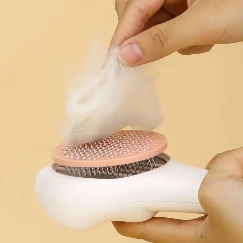 Hand holding pet grooming brush while removing loose fur from the pink pad