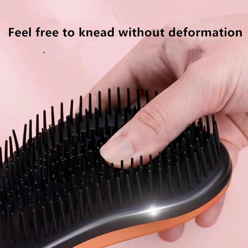Pet grooming brush with rounded base, short black teeth, orange edge accents.