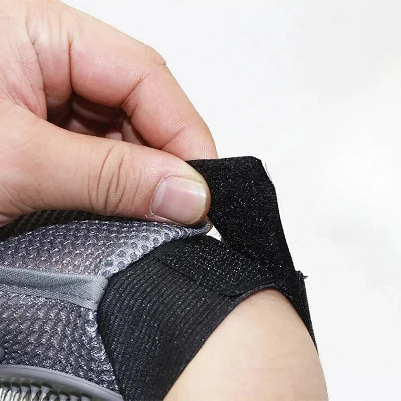 Grey pet grooming mitt showing black wrist strap and textured needle bristle surface